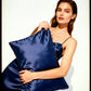 Woman holding a blue silk pillow against a white background